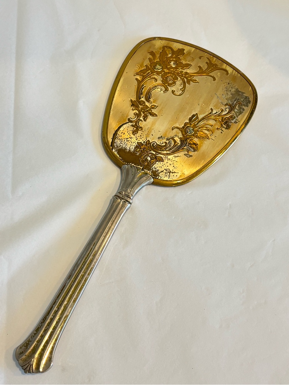 Vintage vanity hand mirror gold tone repousse floral back plate silver handle